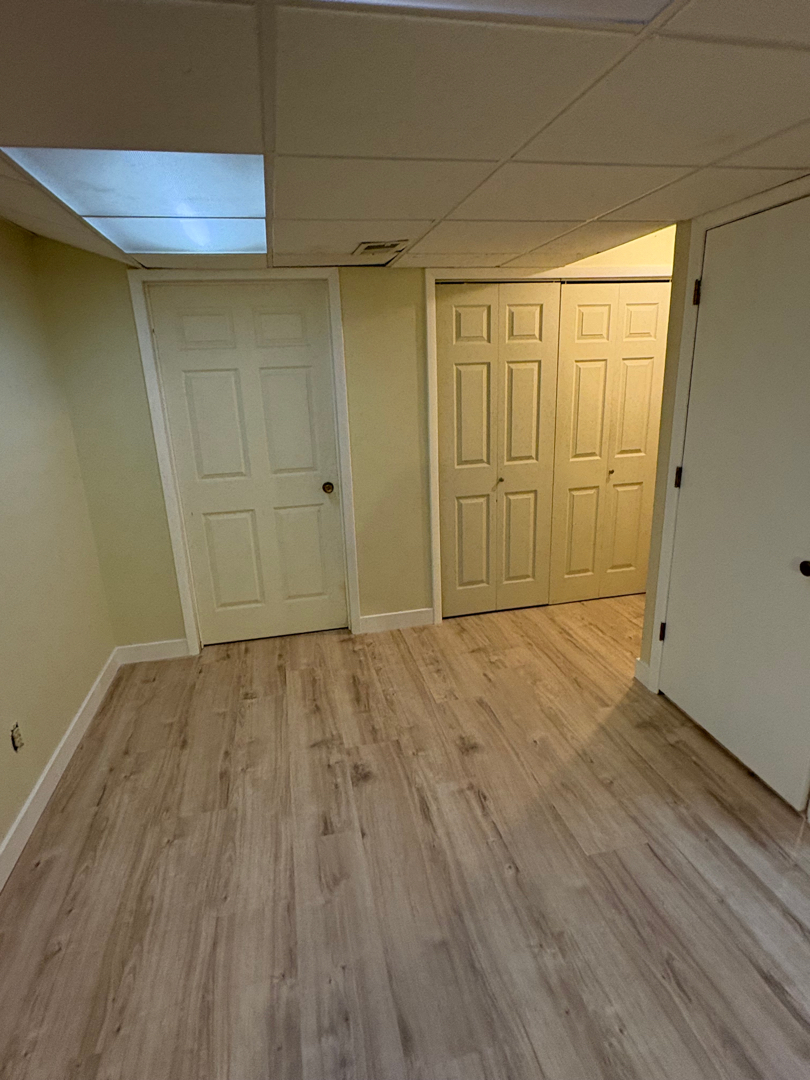Basement room with new luxury vinyl plank flooring installed after water damage