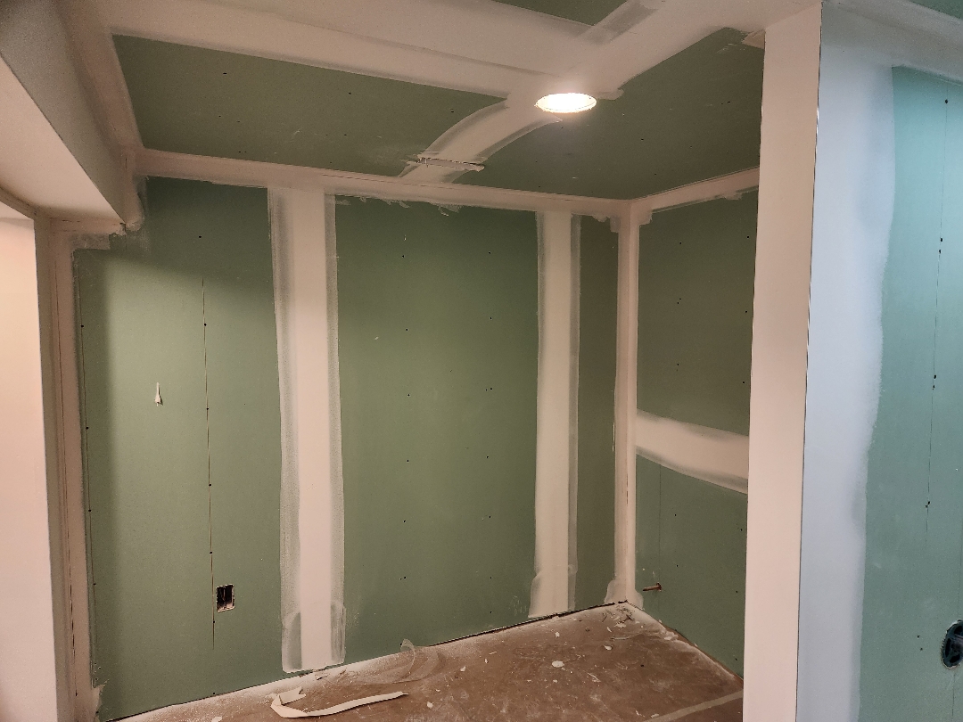 Basement walls being re-drywalled and mudded after water damage remediation